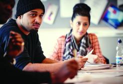 Two students sat at a table, listening in a lecture.
