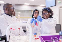 Three students in a practical session in the Bodmer Labs, University of Salford