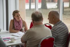 Three seated colleagues in conversation