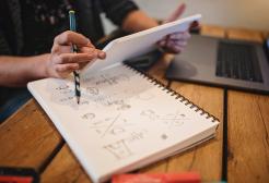 Person making notes on writing pad