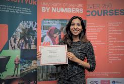 Sweta Suresh holding her SBS PG Excellence Certificate of Recognition