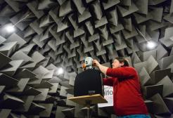 Student working on equipment in the anechoic chamber, Newton Building, University of Salford