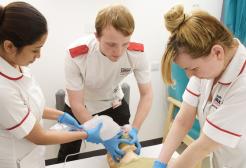 Student nurses stood around a mannequin