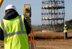 Surveying degree student using construction equipment in a field