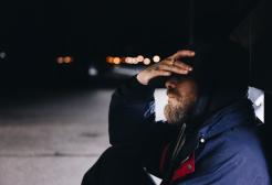 A homeless person sitting alone in the dark
