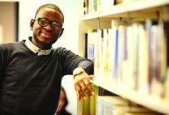 A student in the library next to the book shelves
