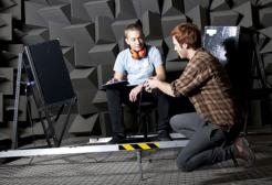 Two students working on equipment in the anechoic chamber, Newton Building, University of Salford