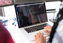 Student working on computer code on a laptop