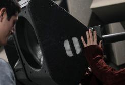 Two students working on equipment in the anechoic chamber, Newton Building, University of Salford