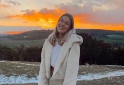 Gemma Gosden stood on hillside with sunset
