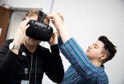 Paige Metcalfe helping a colleague with their virtual reality headset
