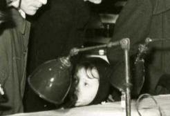 Archive image: A black and white photo shows a boy using a microscope while a younger child looks on. 