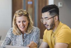 Two students working on a laptop together