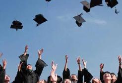 Students graduating, throwing their mortarboards into the air