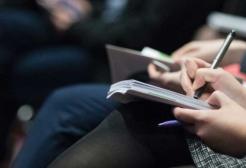 A person takes notes at a press conference