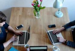 People work on laptops at a table