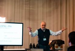 Man giving a lecture with a screen behind him