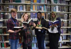 students looking at books in the library