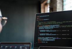 Programmer looking at computer code on a monitor