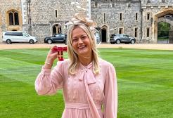 Hannah smiling with her OBE at Windsor Castle