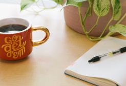 A coffee cup, a notepad and a pen