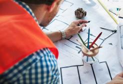 Apprentice reviewing multiple floor plans