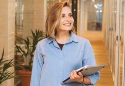 A person walks down a corridor carrying a laptop