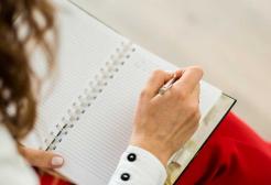 A person writes in a notebook