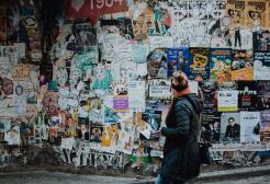 A person looks at posters on a wall
