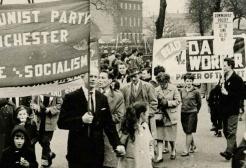 Archive image: A black and white photo shows a Communist Party march through Manchester in the 1960s.