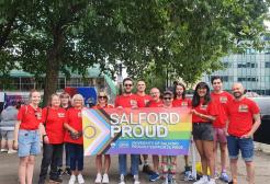 Group of people holding a 'Salford Proud' banner