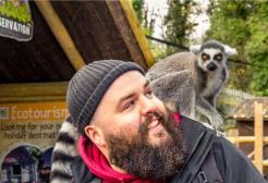 Wildlife student with a lemur on his shoulder