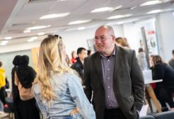 Two people engaged in conversation inside the Maxwell Building, University of Salford