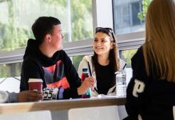 Students sat talking around a table on campus