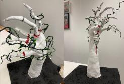 Image shows two image side by side of the sculpture which is a white hand with vines wrapped around the fingers 