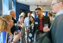 Colleagues in conversation at an alumni event