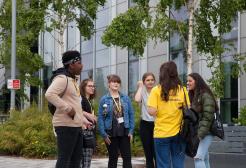 A group of students engaging in conversation with student ambassadors on campus