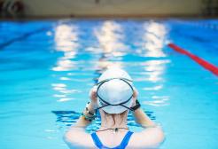 Swimmer adjusting goggles in the University of Salford Sports Centre swimming pool