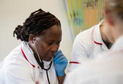 Nurse uses stethoscope to demonstrate to students. 