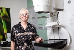 Dr Claire Mercer standing in a lab next to scientific equipment
