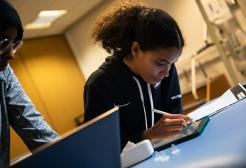Two physiotherapy apprentices doing work on a tablet