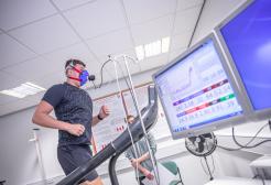 Man running on treadmill with mask monitoring breathing