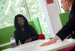 Two people sat at a table in a meeting