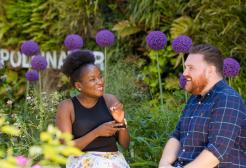 Two people sat in the garden area on campus