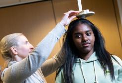 A woman in a white t-shirt measuring another woman's height