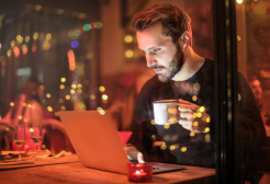 Man with coffee working on a laptop