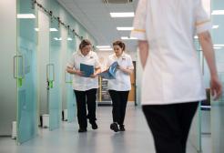 Members of staff walking inside the Podiatry Clinic, University of Salford