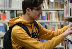 Student searching for books in a library
