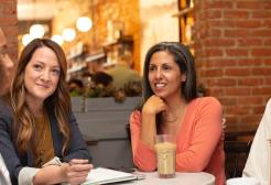 Four women sat talking around a table