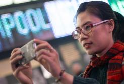 International student Kel holding a phone up taking a picture